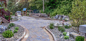 backyard patio with custom border, sitting wall fire pit, landscape waterfall, outdoor grill