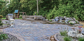 Cambridge pavingstone patio with custom fire pit, sitting wall and outdoor grill, also garden waterfall with small stream build in lagrangeville
